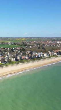 Kılıç Sahili 'nin manzarası ve Hermanville-sur-Mer kıyı kasabası, Normandiya, Fransa, açık mavi gökyüzü ve sakin deniz.