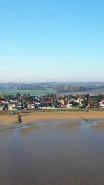 Hermanville-sur-Mer, Normandiya, Fransa 'da kıyı şeridi boyunca uzanan Sword Beach' in havadan görünüşü. Açık mavi gökyüzü ve sakin kıyı manzarası.