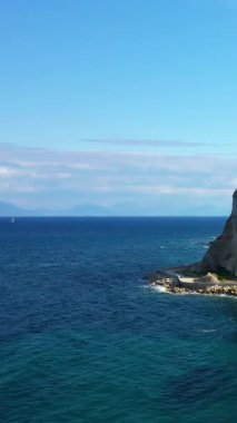 Yunanistan 'ın Koroni kentinde açık bir gökyüzü altında derin mavi denizle buluşan engebeli uçurumların manzarası. Sakin suları ve doğal güzelliği olan sakin Akdeniz manzarası.