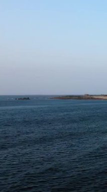 Fransa 'nın Normandiya eyaletindeki Cap de la Hague' de berrak bir gökyüzü altında kayalık bir kıyı şeridi bulunan sakin okyanus suları. Huzurlu deniz manzarası seyahat ve doğa kavramları için ideal..