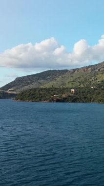 Yunanistan 'ın Plataria kentinin kıyı ve tepelerinin sakin mavi denizi ve dağınık bulutlarıyla manzarası.