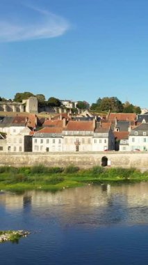 Büyüleyici La Charite-sur-Loire manzarası. Geleneksel evler, antik taş duvarlar ve açık mavi gökyüzünün altındaki Loire nehri..