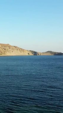 Girit 'teki Triopetra Sahili' nin manzaralı manzarası berrak mavi deniz ve kayan tepeler berrak gökyüzünün altında beyaz evlerle benekli..