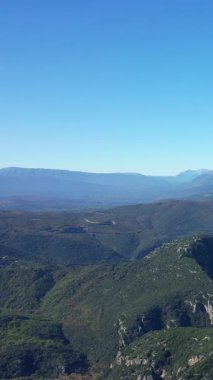 Yunanistan 'ın Vikos-Aoos Ulusal Parkı' ndaki açık mavi gökyüzünün altındaki yemyeşil dağların manzarası. Doğal güzellik ve sükunet, korunan vahşi bir bölgede..
