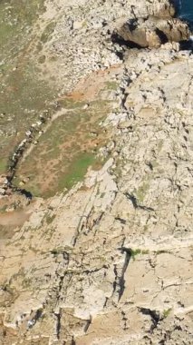 İtalya 'nın Polignano a Mare kıyı şeridi boyunca doğal deniz mağarası olan engebeli kayalık uçurumların havadan görünüşü. Turkuaz deniz kireçtaşı dokusuyla çelişiyor..