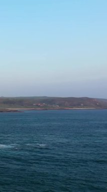 Açık mavi bir gökyüzü altında, Fransa 'nın Normandiya, Cap de la Hague' de, hafif dalgalar ve uzak kıyı şeridi ile geniş deniz manzarası.