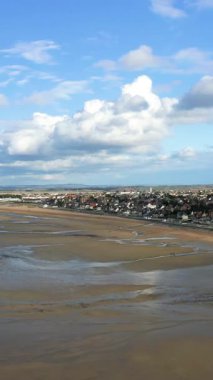 Lion-sur-Mer, Normandiya 'daki Sword Beach' in geniş bir manzarası var. Kıyı kasabası ve kumlu kıyı şeridi üzerinde dramatik bulutlar var..