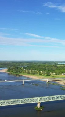 Fransa 'nın Sully-sur-Loire şehrinde açık mavi bir gökyüzünün altında iki köprünün geçtiği Loire nehrinin hava manzarası..