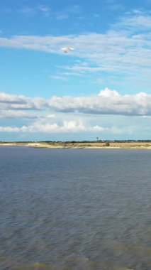 Uzak kırsal kıyı şeridi ile geniş bir nehir manzarası mavi gökyüzü altında dağınık bulutlar, Laos kırsalında yakalandı.