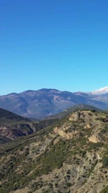 Yunanistan 'daki Osios Loukas Manastırı yakınlarındaki açık mavi gökyüzünün altında engebeli dağların engebeli manzarası..