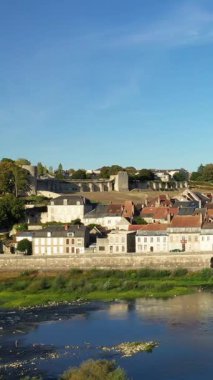 La Charite sur Loire 'nin büyüleyici manzarası. Geleneksel evler ve Loire Nehri boyunca uzanan antik taş duvarlar berrak mavi gökyüzünün altında..
