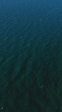 Fransa, Etretat yakınlarında, derin mavi okyanus suyunun havadan çekilmiş görüntüsü. Yüzey doğal gün ışığı altında yumuşak dalgalarla kaplıdır..