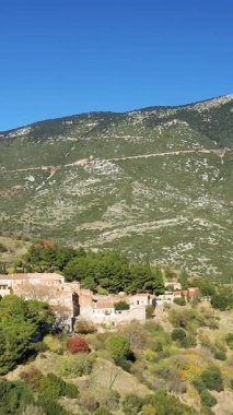 Tarihsel Osios Loukas Manastırı, Yunanistan 'da açık mavi bir gökyüzünün altında yeşil tepeler ve ağaçların arasına kurulmuştur. Geleneksel mimarisi ve canlı doğal çevresi olan manzaralı bir yer..