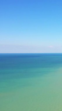 Sakin turkuaz sular ve bernieres-sur-Mer, Fransa 'da sakin bir deniz manzarası yaratır. Huzurlu ve minimalist kıyı sahnesi arka plan veya rahatlama temaları için idealdir.