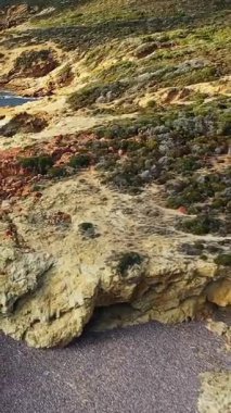 Korsika, Fransa 'daki Delta du Fango kıyı şeridi boyunca engebeli kayalık uçurumların ve berrak mavi denizin manzarası. Dokulu taş ve kıyı bitkileriyle doğal Akdeniz manzarası.