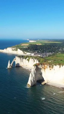 Etretat, Normandiya, Fransa kıyı şeridi boyunca uzanan dramatik beyaz tebeşir kayalıklarının ve doğal kemerlerin açık mavi gökyüzünün altında havadan görünüşü.