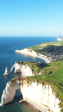 Açık bir yaz gününde Etretat, Normandiya, Fransa 'nın ikonik beyaz tebeşir kayalıklarının ve turkuaz kıyı şeridinin havadan görünüşü.