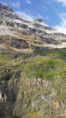 Fransa 'nın Pireneler şehrinde Gavarnie Sirki' nde, mavi gökyüzünün altında yeşil yamaları olan sarp kayalıklar. Dramatik doğal manzara macera ve seyahat kavramları için ideal..