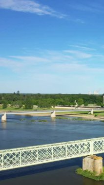 Fransa 'nın Sully-sur-Loire şehrinde yemyeşil ve mavi gökyüzü ile Loire Nehri' ni geçen birden fazla köprü manzarası.