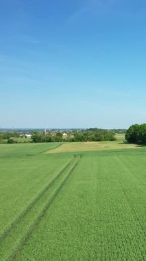 Fransa 'nın Normandiya kentindeki Hillman Bataryaları yakınlarında açık mavi bir gökyüzü altında yemyeşil alanlar geniş bir görüş alanına sahiptir. Ağaçlar ve uzak kırsal binalar huzurlu kırsal alanı tamamlıyor.