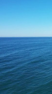 Portekiz 'in Albufeira yakınlarındaki Algarve sahilinden bakıldığında berrak bir gökyüzü altında sakin mavi okyanus suyu. Huzur, seyahat ve doğa kavramları için mükemmel..