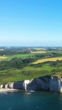 Dramatik beyaz tebeşir uçurumları, yemyeşil alanlar ve Fransa 'nın Normandiya kıyıları boyunca uzanan mavi deniz manzarası..
