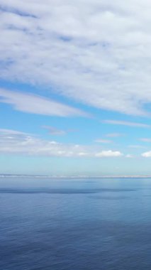 İtalya 'nın Napoli Körfezi' nde uzak kıyı şeridi bulunan parçalı bulutlu bir gökyüzünün altında sakin mavi bir deniz. Huzurlu deniz manzarası seyahat ve doğa kavramları için idealdir.