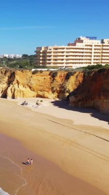Dramatik uçurumlar, kumlu plajlar ve Albufeira, Algarve, Portekiz 'de modern bir tatil yeri olan güneşli sahil manzarası..