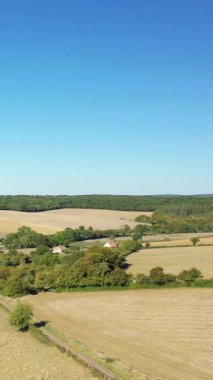Açık güneşli bir günde Fransa 'nın Cuncy les Varzy yakınlarındaki kırsal kesimde tarlaların, ağaçların ve dağınık evlerin havadan görünüşü.