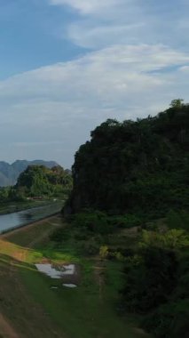 Laos 'un Nam Theun 2 bölgesinde çekilen yoğun yeşil tepelerin ve bulutlu bir gökyüzünün altındaki ormanlık arazinin manzarası..