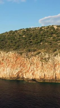 Yunanistan 'ın Mani bölgesinde, güneşli bir gökyüzünün altında, Diros plajı yakınlarındaki engebeli uçurumlar ve berrak mavi deniz manzarası.