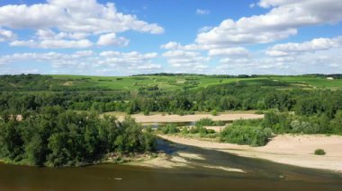 Loire nehri manzaralı, yemyeşil üzüm bağları ve Pouilly yakınlarındaki yuvarlanan tepeler bulutlu mavi bir gökyüzünün altında..
