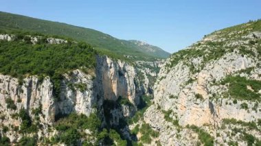 Fransa 'nın güneyindeki açık mavi gökyüzünün altında Verdon Boğazı' nın yeşil yamaçları ve dramatik kireçtaşı kayalıkları. Seyahat ve macera kavramları için muhteşem doğal manzara..