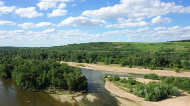 Pouilly yakınlarındaki yuvarlanan tepelerde yemyeşil üzüm bağlarıyla Loire Nehri 'nin manzaralı manzarası dağınık bulutlu mavi bir gökyüzünün altında.