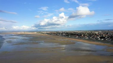 Ouistreham, Normandiya, Fransa 'da kıyı kasabasında geniş kum ve dramatik bulutlarla birlikte Kılıç Sahili' nin havadan görünüşü.
