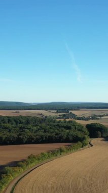 Fransa 'nın kırsal kesimindeki Cuncy les Varzy yakınlarında açık mavi bir gökyüzünün altında yuvarlanan tarlaların, ormanların ve uzak tepelerin havadan görünüşü.