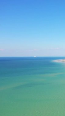 Bernieres-sur-Mer, Normandiya 'daki Juno Sahili' nin sakin turkuaz suları ve kumlu kıyı şeridi berrak mavi gökyüzünün altında..