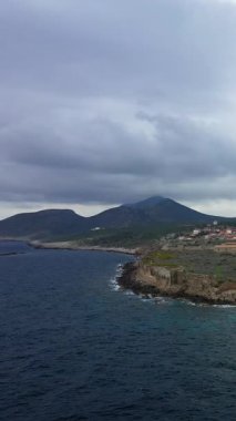 Derin mavi denizi ve Yunanistan 'ın Methoni kenti yakınlarında bulutlu gökyüzü olan Rocky sahili. Engebeli kayalıklar Akdeniz sularıyla bulutlu havada karşılaşıyor..