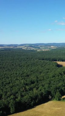 Fransa 'nın Saint-Honore-les-Bains yakınlarındaki yama alanlarının ve kırsal alanların hava manzarası, dağınık bulutlu mavi bir gökyüzünün altında..