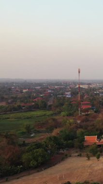 Krong Preah Vihear şehrinin yüksek açılı insansız hava aracı görüntüleri. Dağınık evler, ağaçlar ve sisli bir gökyüzü altında geleneksel mimari..