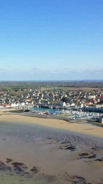 Marina manzaralı, kumlu bir sahil, ve Grandcamp-Maisy, Normandiya, Fransa 'da büyüleyici bir sahil köyü, açık mavi bir gökyüzü altında..