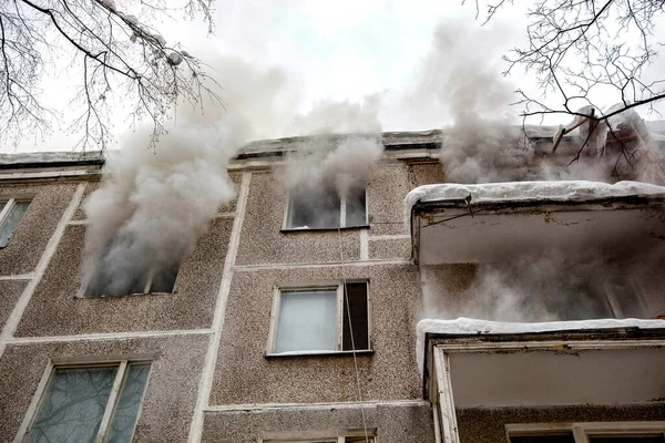 Three firefighters extinguish a fire in an apartment house