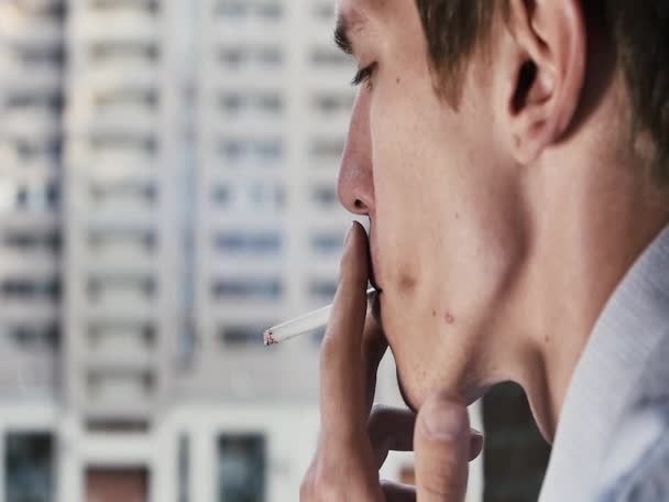 Joven oficinista fuma un primer plano de cigarrillos en el fondo de la calle — Vídeo de stock