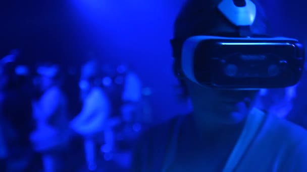 Старуха в очках виртуальной реальности на технологическом шоу — стоковое видео