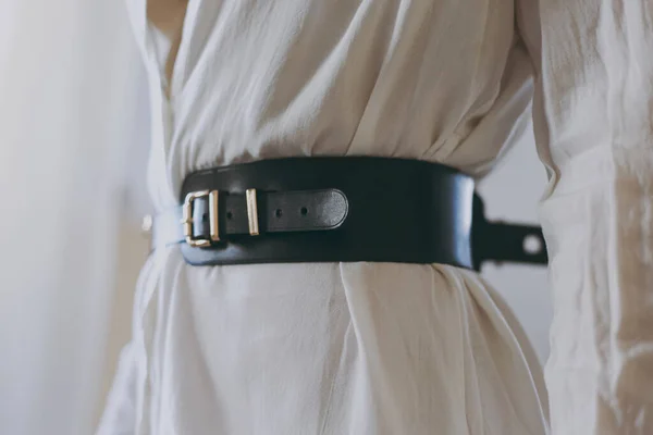 Beyaz ofis tişörtlü genç kız deri kemer deniyor.