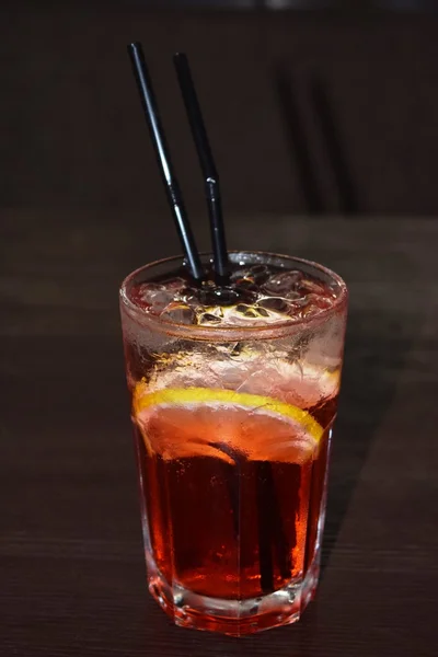 De koude rode limonade in een glas met een rietje — Stockfoto