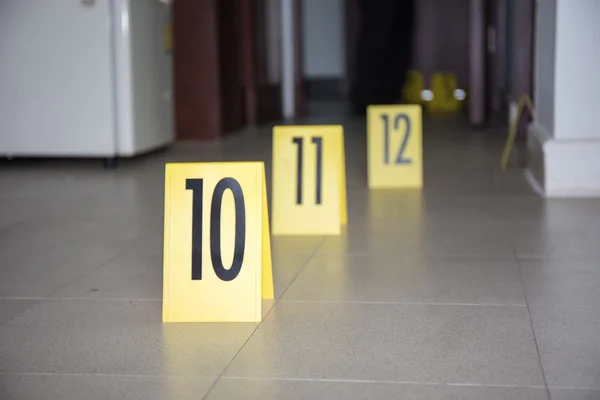 evidence marker at stain on room floor in crime scene