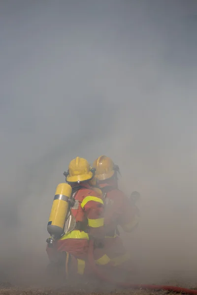 Два пожежники працюють навколо диму — стокове фото