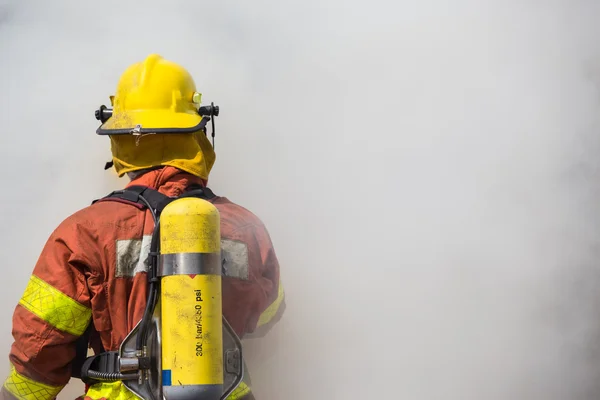 Einzelner Feuerwehrmann im Einsatz mit Rauch umgeben — Stockfoto