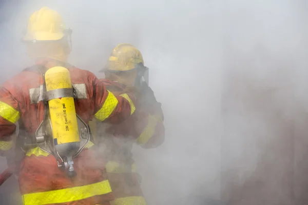 2 пожежників в експлуатації в оточенні диму — стокове фото